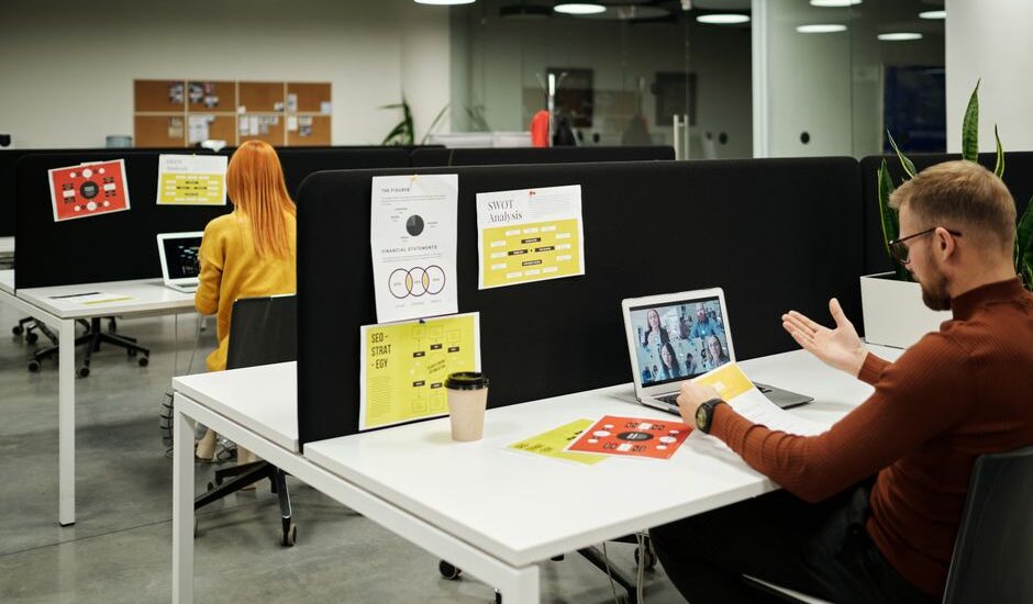 Colleagues working and collaborating virtually at a stylish modern office workspace.